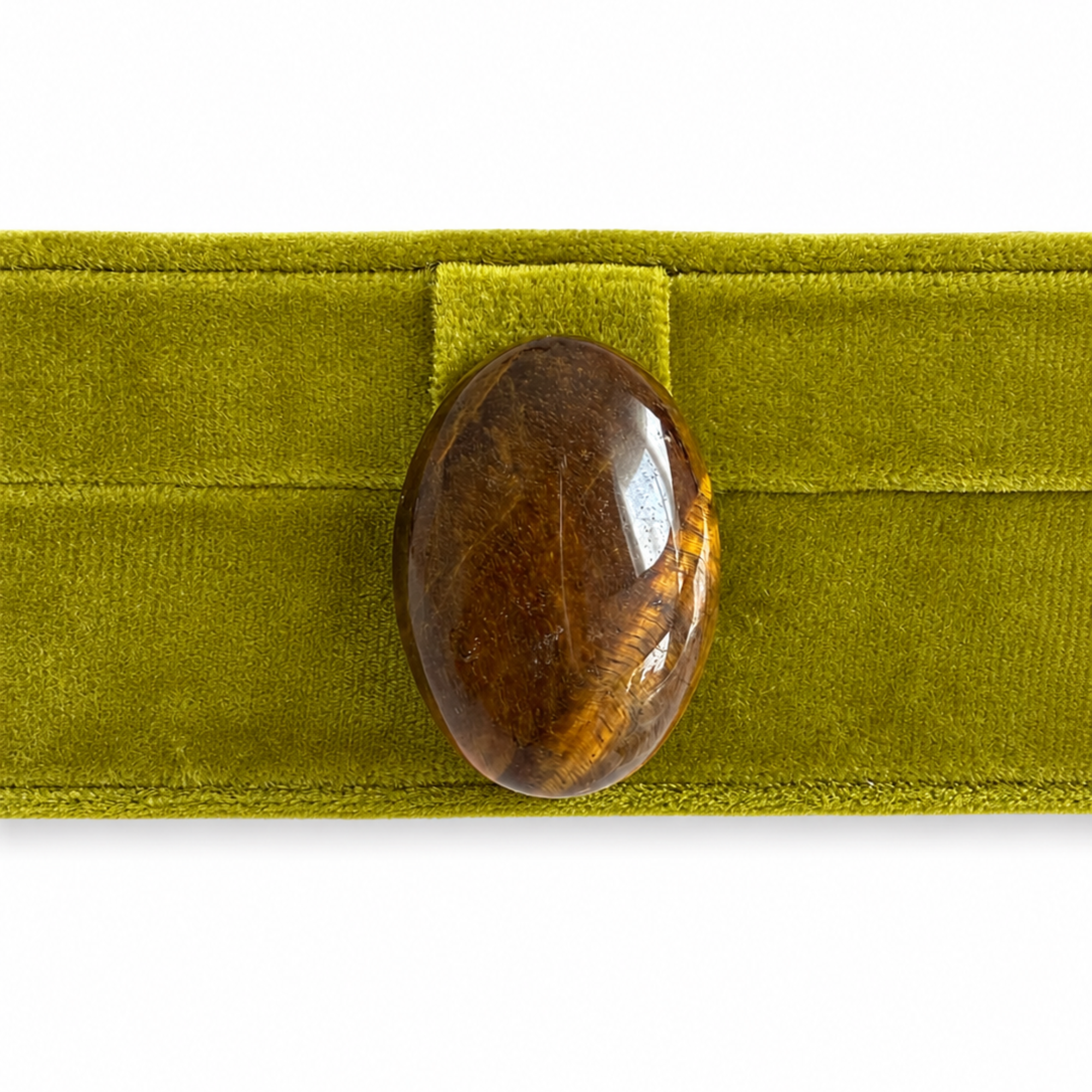 A polished brown tiger's eye stone pendant resting on a textured olive green velvet ribbon, set against a plain white background.