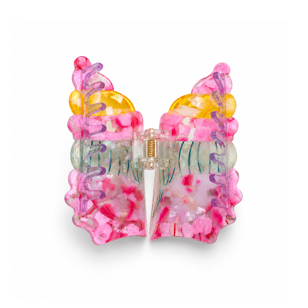 A translucent seashell-shaped hair claw clip in a vibrant multicolor design, featuring pink, yellow, blue, and green swirls with rhinestone accents, set against a plain white background.